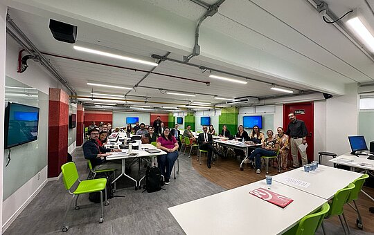 Foto de uma sala do Mackenzie cheia com diversas pessoas 