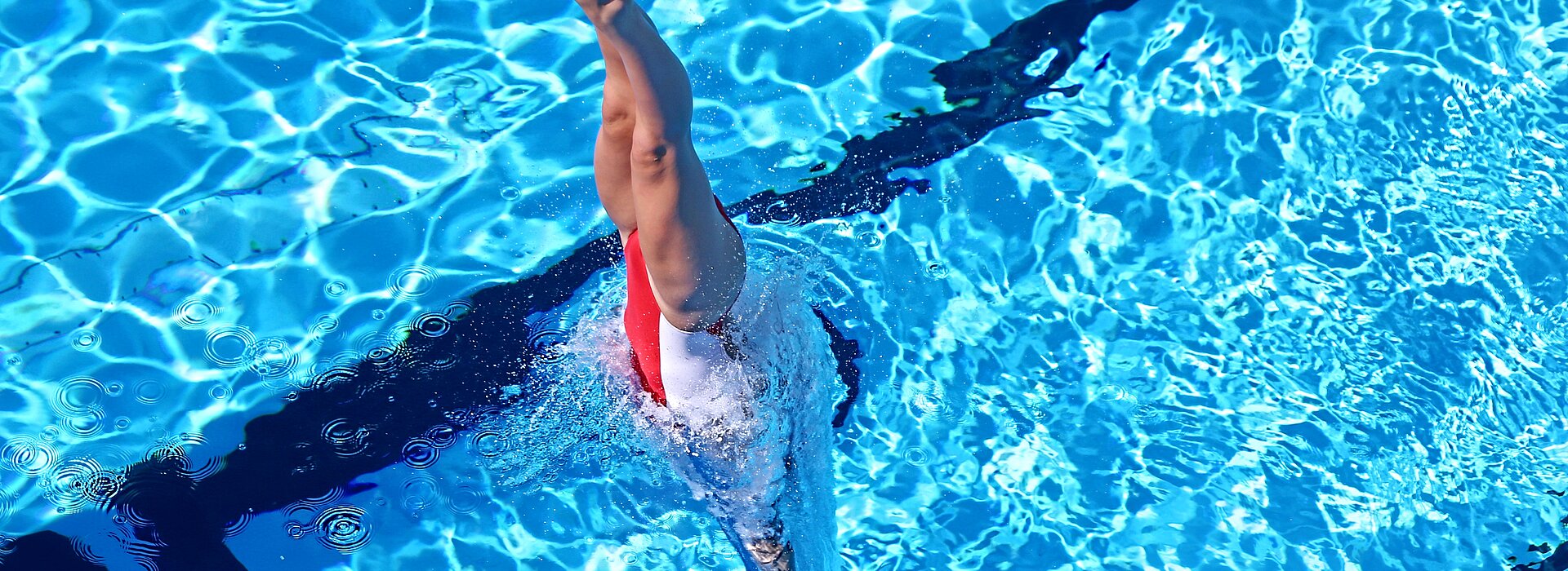 Atleta treinando nado artístico na piscina 