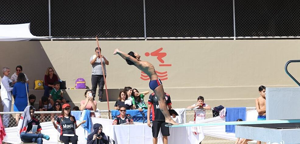 Aluno saltando do trampolim de costas