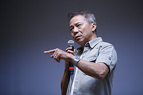 Thái gesticula durante sua apresentação na noite