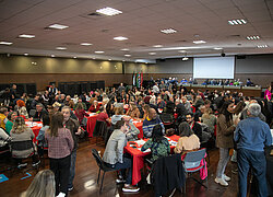 Imagem tirada do "XI Fórum de Aprendizagem Transformadora" e nela contem um auditório cheio pessoas sentadas debatendo.
