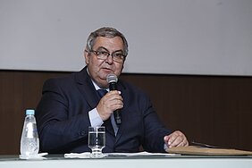 Roberto Brasileiro, com microfone sentado à mesa