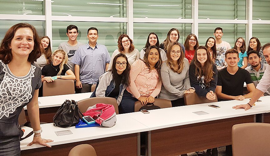 Participantes da palestra posando para foto estando alguns sentados e outros de pé