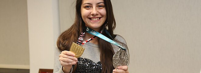Júlia mostrando medalhas 