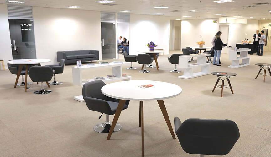 ampla sala com mesas e cadeiras para usos diversos