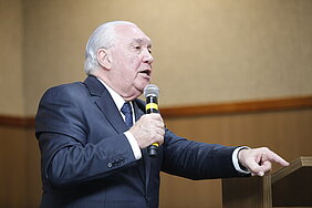 Homem em pé com microfone na mão