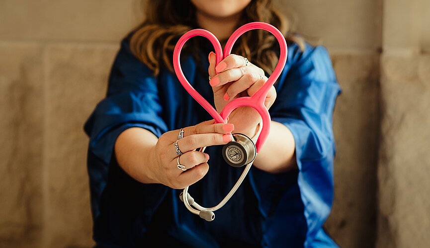 profissional da saúde segurando seu estetoscópio em formato de coração