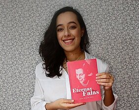 Autora Louise Teixeira Diório segurando seu livro