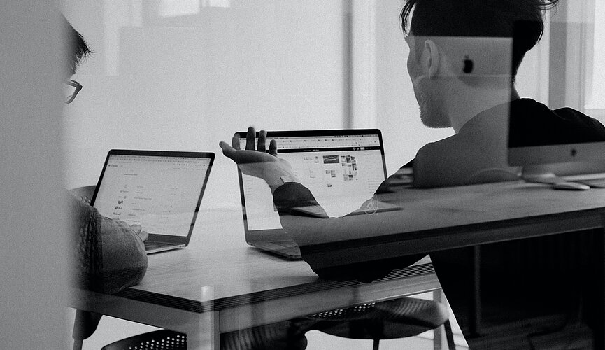 Imagem retrata um moço com um computador