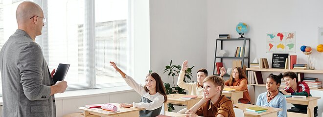 Professor e crianças na sala de aula enpolgadas para aprender